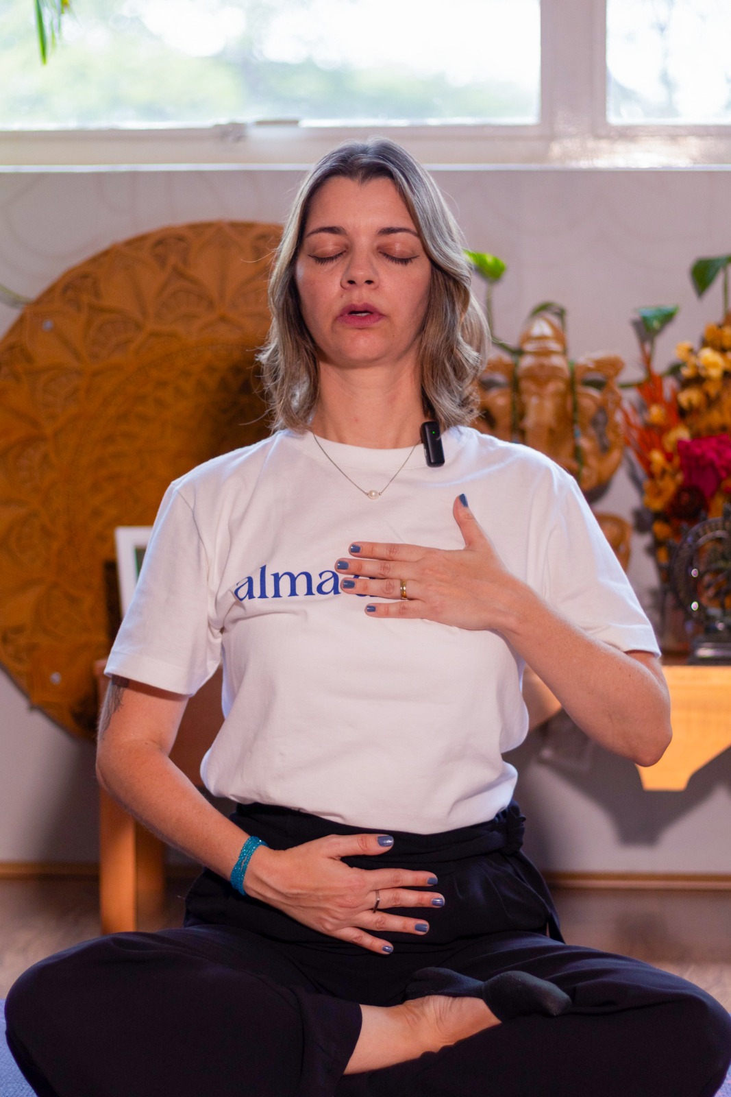 Carol em prática de respiração consciente, mãos no peito e ventre